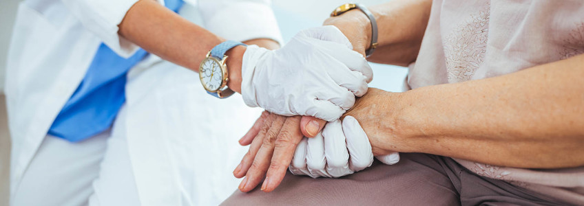 médica segura nas mãos de paciente sénior