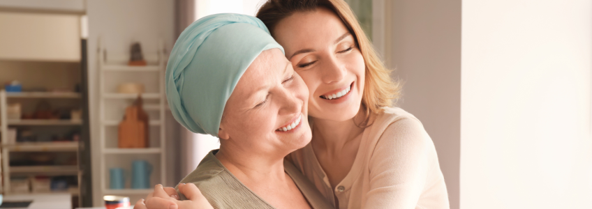 Mulher com cancro a receber um abraço da cuidadora