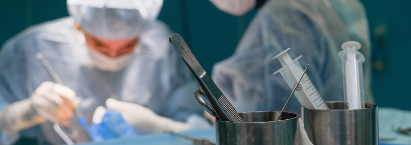 Bloco operatório com médico cirurgião a operar e retirar parte de um tumor
