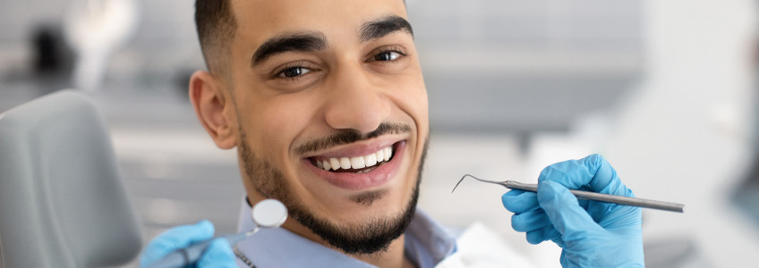 rapaz a sorrir no dentista
