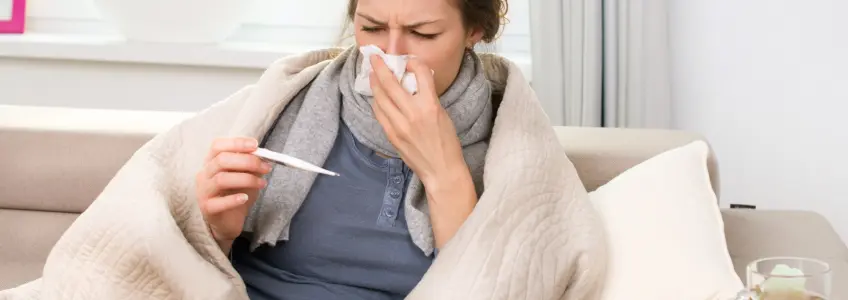 mulher com gripe a medir a febre