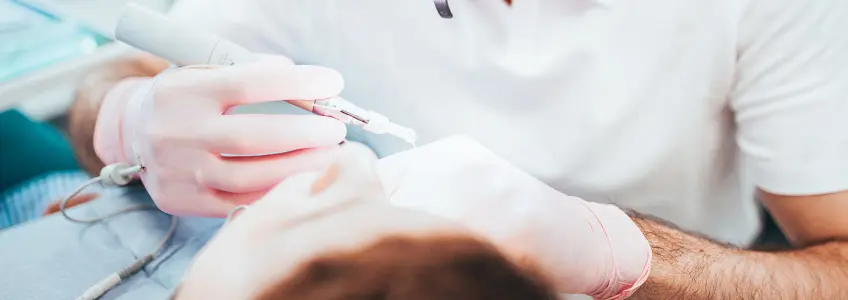 dentista a fazer tratamento em paciente