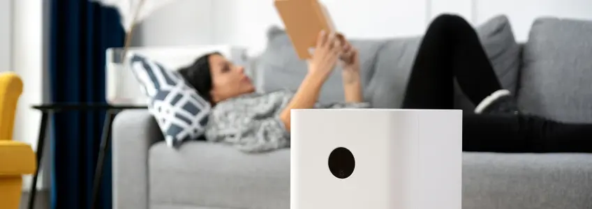 purificador de ar funciona na sala enquanto rapariga lê livro