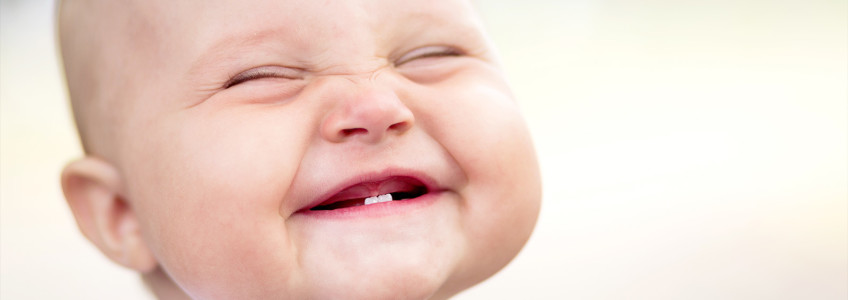 bebé a sorrir com dois dentes