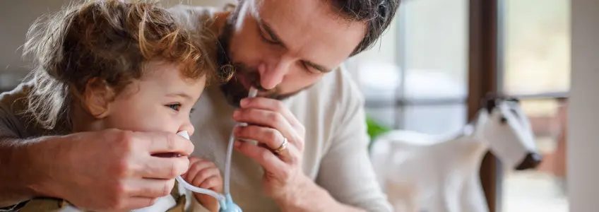 pai a usar aspirador nasal na filha para tratar a tosse