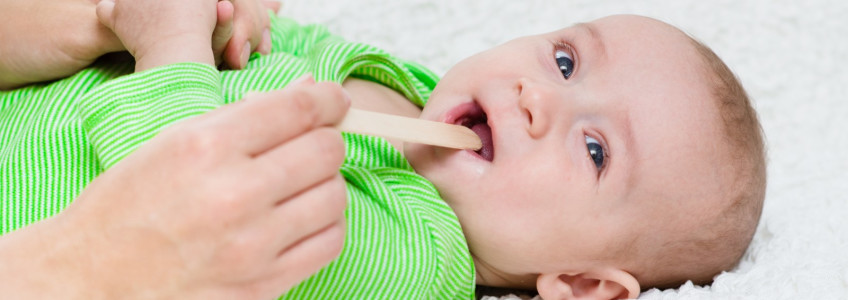 pediatra observa a boca de um bebé