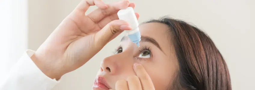 rapariga a colocar gotas nos olhos