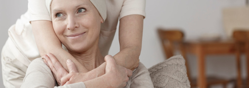 mulher a abraçar carinhosamente doente com cancro