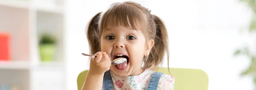 menina a comer um iogurte