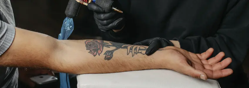 homem a ser tatuado no braço
