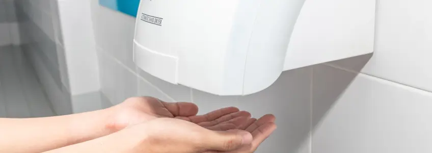 homem a secar as mãos em secador automático