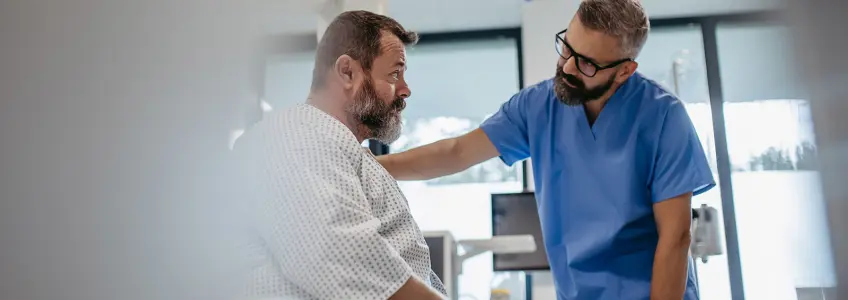 médico a falar com paciente sentado na marquesa