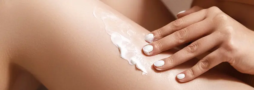 mulher a aplicar creme para a celulite nas pernas