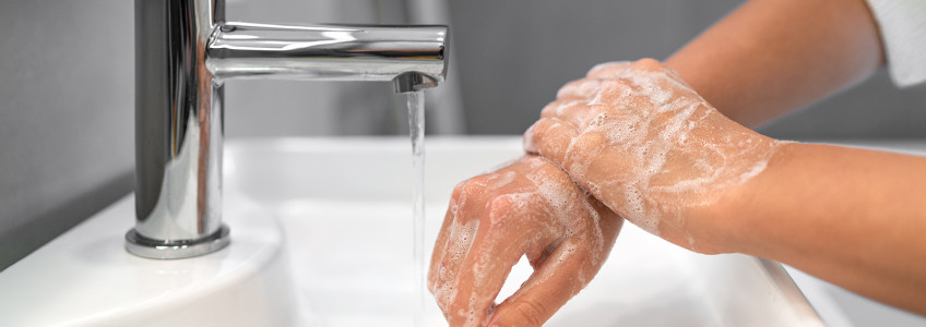 mulher a lavar as mãos com sabão