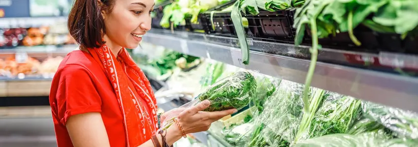 mulher no supermercado a escolher vegetais
