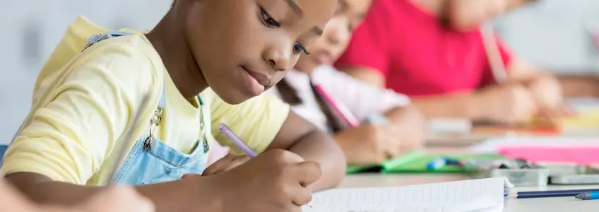 menina muito concentrada na sala de aula